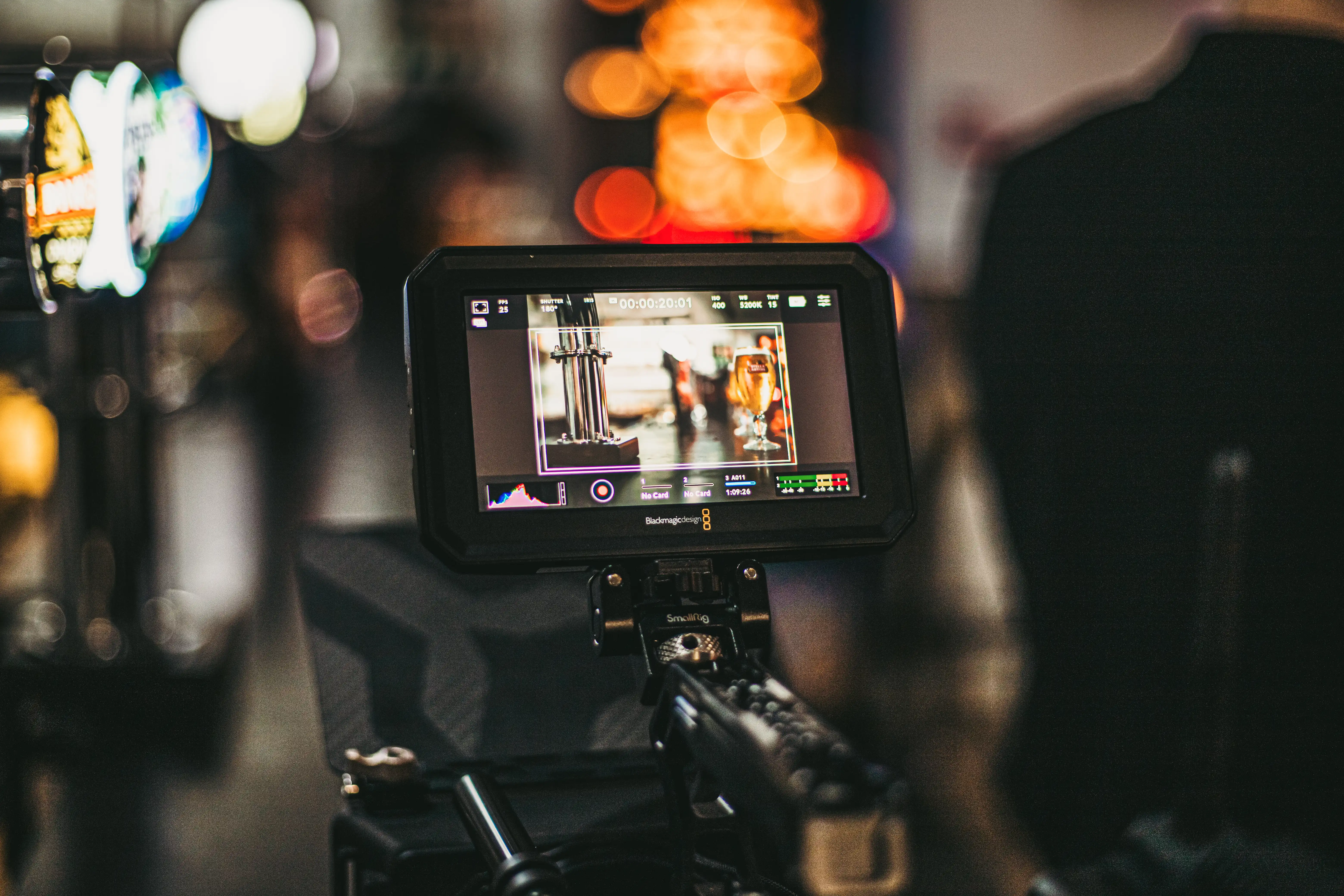 A close up of a professional videography camera. The background is blurred.